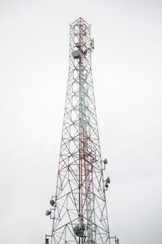 A tall telecommunication tower with antennas against a cloudy sky, symbolizing connectivity.